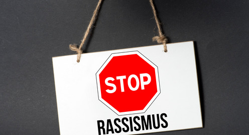 Ein Stopschild, darunter steht der Begriff "Rassismus"